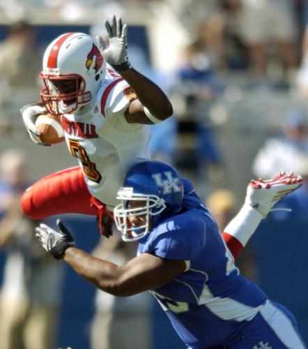 University of Louisville's wide receiver Joshua Tinch dives overtop University of Kentucky's Lamar Mills for extra yardage