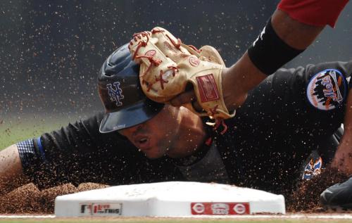 New York Mets Carlos Beltran is taged out by Cincinnati Reds third baseman Edwin Encarnacion at third base during the second inning of play in their MLB National League baseball game at Great American Ball Park in Cincinnati