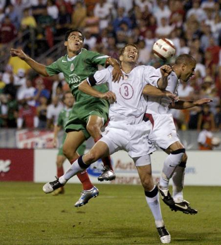 Mexico's Omar Bravo fights for the ball with Gregg Berhalter of the U.S. and Chris Armas during the second half