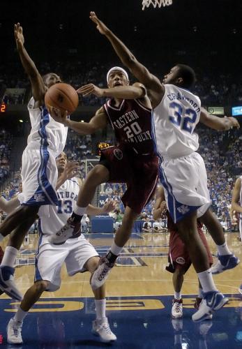 Eastern Kentucky University's Mike Rose fights to get his shot off under pressure from University of Kentucky's Ramel Bradley and Joe Crawford in Lexington